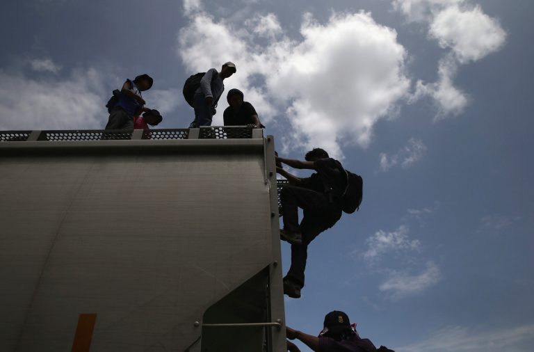 Central American immigrants arrive on top of a freight train on August 6, 2013, to Ixtepec, Mexico. (Photo by John Moore/Getty images)