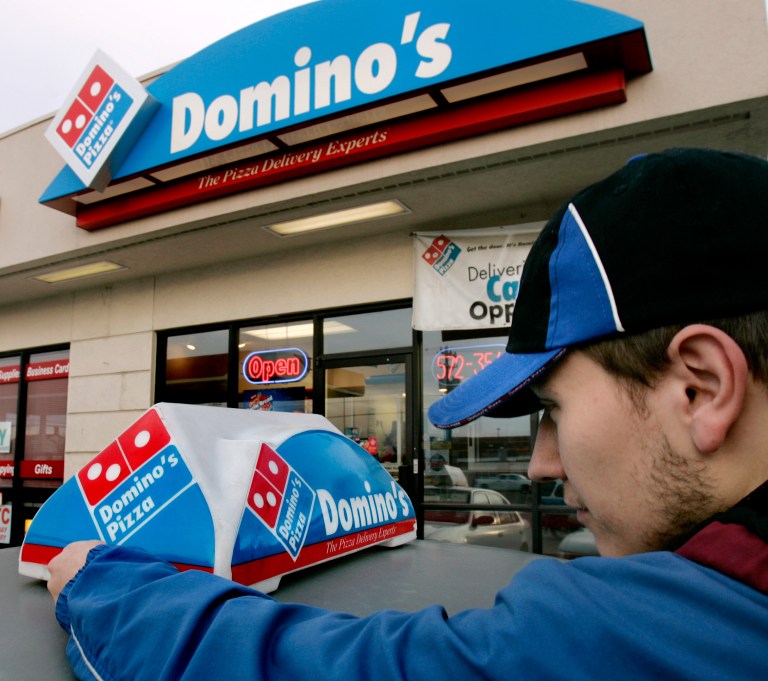 FILE - In this Feb. 21, 2007 file photo, Domino's Pizza delivery person Brandon Christensen plugs in the company sign atop his car in Sandy, Utah. The pizza delivery chain on Monday, June 16, 2014 plans to introduce a function on its mobile app that lets customers place orders by speaking with a computer-generated voice named 
