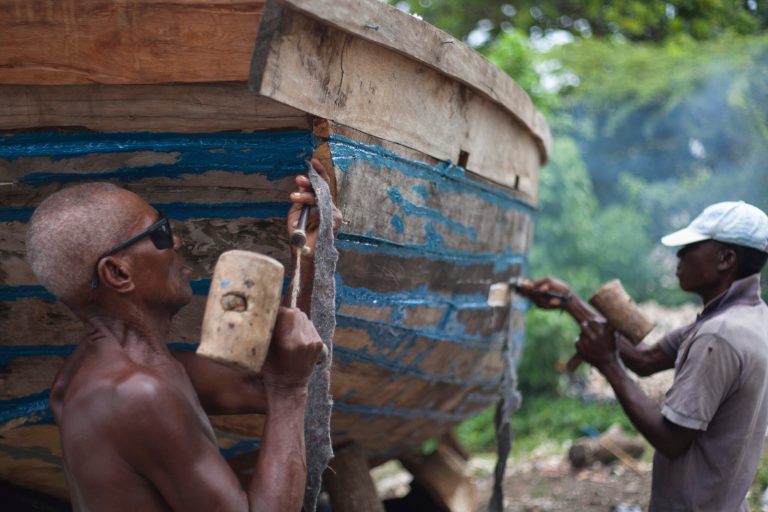 In this May 4, 2013 photo, workers build a sailboat on the beach of Leogane, Haiti. The 30-foot-long boats are purchased by smugglers for around $12,000 and then taken to northern Haiti to find passengers. There are no official statistics on how many Haitians have successfully made their way illegally to Puerto Rico, or how many have traveled on to the U.S. mainland. But the trend worries officials in the U.S. and the Dominican Republic, with both countries reporting that arrests of Puerto Rico-bound Haitians have soared. (AP Photo/Dieu Nalio Chery)