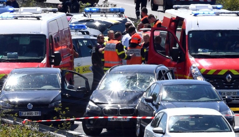 French security forces and emergency vehicles surround a car, centre, on a highway between Boulogne-sur-Mer and Calais in northern France that authorities say was used in an attack on soldiers near Paris on Wednesday. French authorities say the driver was arrested and injured by police fire, and is considered the chief suspect in the attack on the soldiers. (AP Photo)