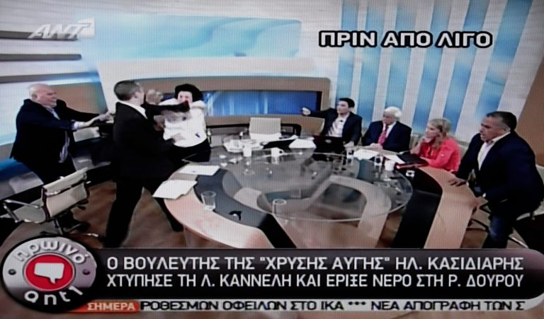   In this image taken off a TV screen, Ilias Kasidiaris, 2nd left, spokesman of Greece's extremist far-right Golden Dawn party, who was elected to Parliament in the country's recent inconclusive polls, physically assaults Liana Kanelli, a female member of the Parliament for the Greek Communist party, during a talk show at the studios of the ANTENA TV station in Athens on Thursday, June 7, 2012. Kasidiaris bounded out of his seat and slapped Kanelli three times after throwing a glass of water over radical left Syriza party member Rena Dourou. Police have issued an arrest warrant for Kasidiaris after he physically assaulted the two left-wing deputies on live television during a morning political show. (AP Photo/ANTENA TV) TV OUT  