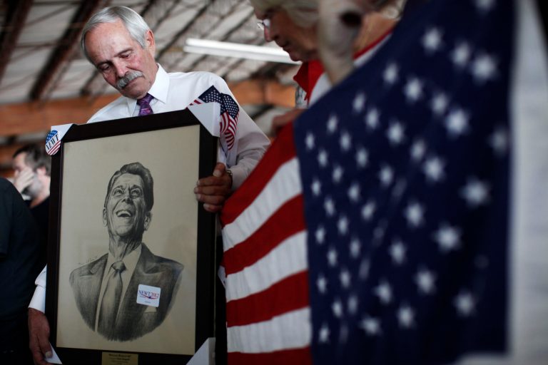 Robert Baron holds an image of President Ronald Reagan at Dolphin Aviation in Sarasota, Fla. (AP Photo/Matt Rourke)