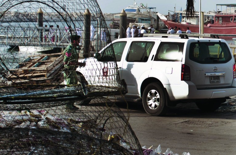 Emirati police and other officials inspect a boat docked in a fishing harbor in the Jumeirah district of Dubai, United Arab Emirates, Monday, July 16, 2012. A U.S. official in Dubai says an American vessel has fired on a boat off the coast of the United Arab Emirates, killing one person and injuring three. The official gave no further details, but it appears the boat could have been mistaken as a threat in Gulf waters not far from Iran's maritime boundaries. (AP Photo/Almoutasim Almaskery)