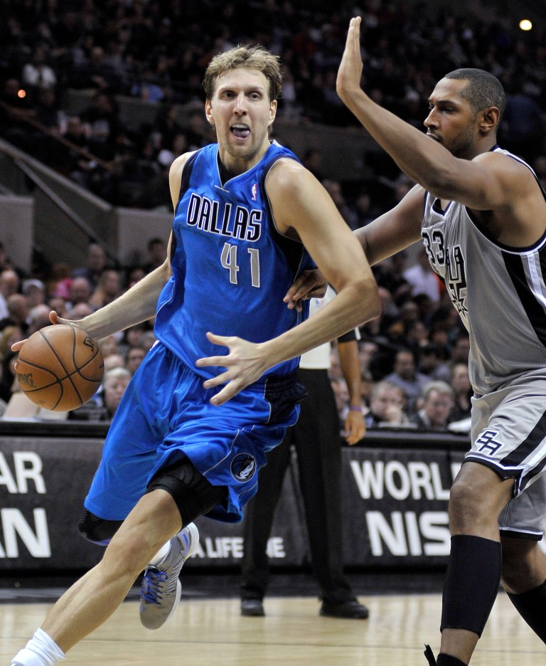   Dallas Mavericks' Dirk Nowitzki, left, of Germany, drives around San Antonio Spurs' Boris Diaw, of France, during the second half of an NBA basketball game, Sunday, Dec. 23, 2012, in San Antonio. San Antonio won 129-91. (AP Photo/Darren Abate)  