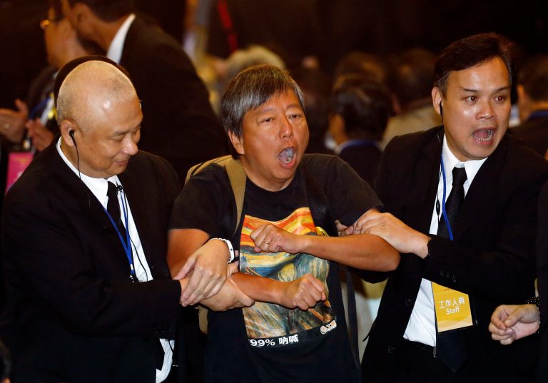 Pro-democracy lawmaker Lee Cheuk Yan, center, is taken away by security guards after a protest against Li Fei, deputy secretary general of the National Peopleâs Congress Standing Committee, in Hong Kong Monday, Sept. 1, 2014. China's legislature on Sunday ruled out allowing open nominations in the inaugural election for Hong Kong's leader, saying they would create a 
