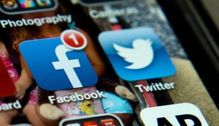 FILE - This May 21, 2013 file photo shows an iPhone in Washington with Twitter, Facebook, and other apps. Technology has changed the long-distance relationship, keeping couples in separate cities or even separate continents connected via video chats and messages.