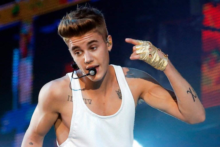 FILE - In this March 19, 2013, file photo, singer Justin Bieber performs during a concert at Bercy Arena in Paris. Canadian police say the pop star has been charged Tuesday, Sept. 2, 2014, with dangerous driving and assault after a collision between a minivan and an ATV led to a physical altercation in southwestern Ontario. Ontario Provincial Police say that the incident happened Friday afternoon, Aug. 29,  near Bieber's hometown of Stratford and that he was released on a promise to appear in court Sept. 29.   (AP Photo/Francois Mori, File)