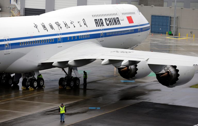 A worker walks next to a Boeing 747-8 Intercontinental airplane to be delivered to Air China, Monday, Sept. 29, 2014, in Everett, Wash., before a delivery ceremony. (AP Photo/Ted S. Warren)