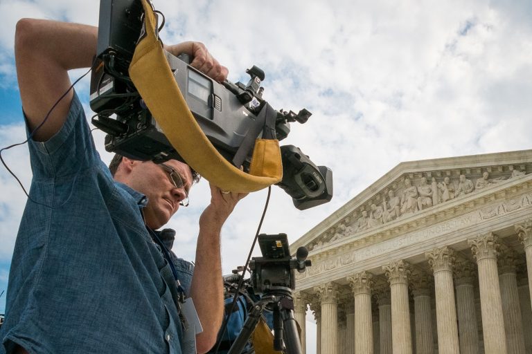 A videojournalist sets up outside of the Supreme Court in Washington, Tuesday, April 22, 2104. The court is hearing oral arguments between Aereo, Inc., an Internet startup company that gives subscribers access to television on their laptops and other portable devices and the over-the-air broadcasters. (AP Photo/J. David Ake)