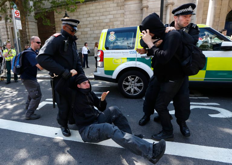 Police officers drag two counter demonstrators, United Against Fascism's supporters, away from a confrontation with English Defence League's supporters at Whitehall, London Monday, May 27, 2013. EDL supporters marched to Downing Street to protest in support of the British armed forces, after the brutal killing of an off-duty British soldier in a London street last week.(AP Photo/Sang Tan)