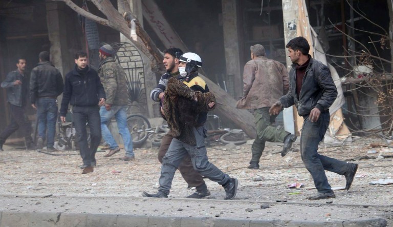 This photo provided by the Syrian Civil Defense White Helmets, which has been authenticated based on its contents and other AP reporting, shows a civil defense worker carrying a victim after airstrikes hit a rebel-held suburb near Damascus, Syria, Thursday, Feb. 8, 2018. Syrian rescue workers and activists say the death toll from ongoing government strikes on the opposition-held region near the capital Damascus has risen to at least 35. (Syrian Civil Defense White Helmets via AP)