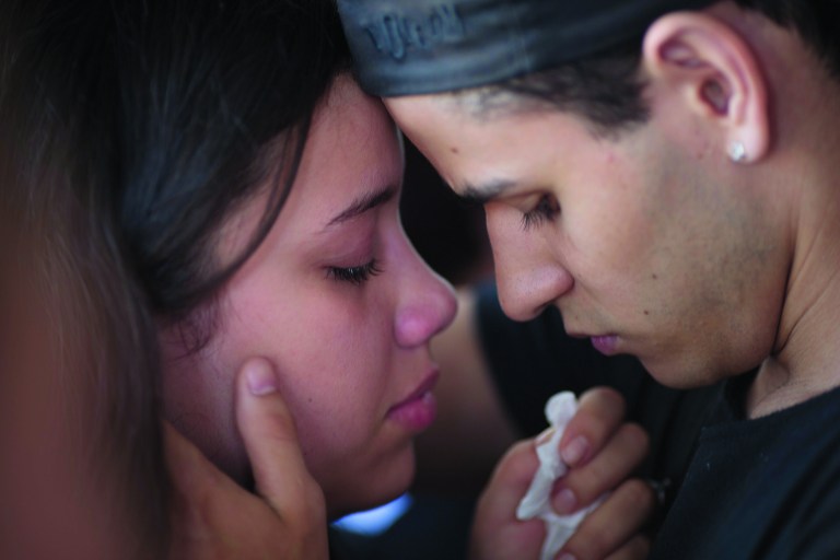 **CORRECTS GENDER OF MOURNER ON RIGHT**A woman weeps as she is comforted by a man during the funeral of Gustavo Goncalves, the most recent victim of the Kiss nightclub fatal fire raising the death toll to 235, in Santa Maria, Brazil, Wednesday, Jan. 30, 2013. A fast-moving fire roared through the crowded, windowless nightclub in this southern Brazilian city early Sunday. The first funeral services were held Monday for the victims. Most of the dead were college students 18 to 21 years old, but they also included some minors. (AP Photo/Felipe Dana)