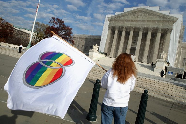 Same-sex marriage proponent Kat McGuckin of Oaklyn, New Jersey, holds a gay marriage pride flag while standing in front of the Supreme Court on Nov. 30, 2012, in Washington. (Chip Somodevilla/Getty images)