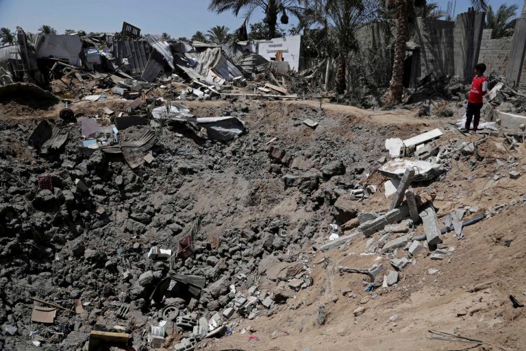 A Palestinian youth looks at damages in front of a crater caused by an Israeli strike on the al-Louh family house in Deir el-Balah, in the central Gaza Strip, early Wednesday, Aug. 20, 2014. Many were killed in an airstrike on the house of the al-Louh family in Deir el-Balah, including a mother, father, three children, and two brothers of the father, according to Gaza health official Ashraf al-Kidra. (AP Photo/Adel Hana)