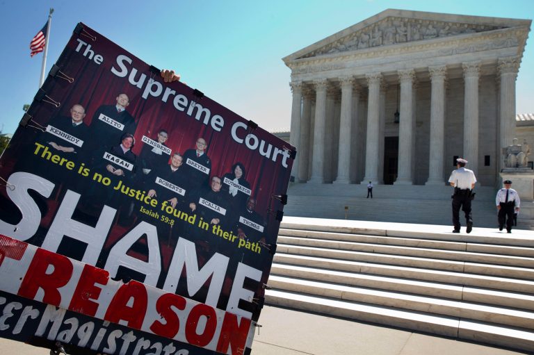 A protester who was against the gay marriage decision carries a sign of the Supreme Court Justices, outside of the Supreme Court in Washington, Monday June 29, 2015. (AP Photo/Jacquelyn Martin)