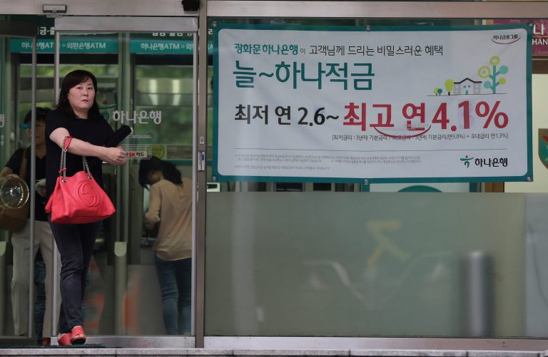 A woman walks past an advertisement for a bank's interest rate in Seoul, South Korea, Thursday, Aug. 14, 2014. South Korea's central bank, Bank of Korea, cut its key interest rate for the first time in 15 months on Thursday, providing support to an economy dragged down by the shock of a ferry sinking that killed hundreds of teenagers. The banner reads: 