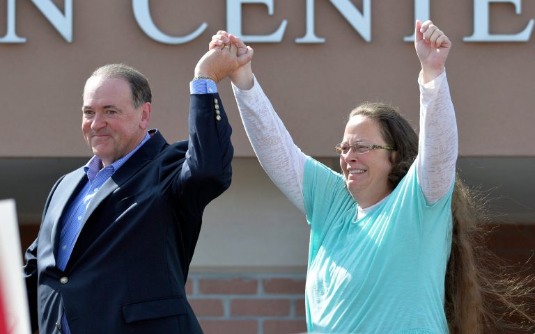 Rowan County Clerk Kim Davis, with Republican presidential candidate Mike Huckabee, left, at her side, greets the crowd after being released from the Carter County Detention Center, Tuesday, Sept. 8, 2015, in Grayson, Ky. (AP Photo/Timothy D. Easley)