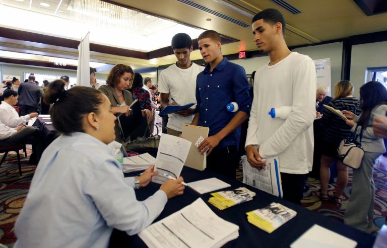 FILE - In this Wednesday, Aug., 14, 2013 file photo, job seekers Emilio Ferrer, Brian Ferrer,  center, and Jonathan, right, of  Hollywood, Fla., talk to a FirstService representative at a job fair in Miami Lakes, Fla. The government reports on job openings and labor turnover for August on Thursday, Oct. 24, 2013. (AP Photo/Alan Diaz, File)
