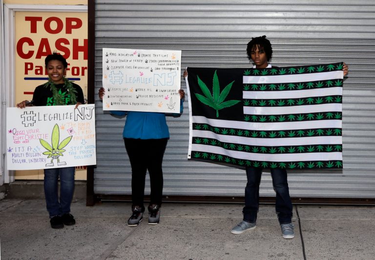 Pro-marijuana activists hold signs as they stand in Trenton, N.J., on April 20. (AP/Mel Evans)