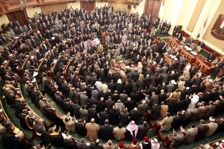   FILE - In this Monday, Jan. 23, 2012 file photo, members of parliament stand and pray for the souls of the victims who died during the uprising that ousted President Hosni Mubarak during the first Egyptian parliament session after the revolution, in Cairo, Egypt. Egypt's highest court has ordered the country's Islamist-dominated parliament dissolved, saying its election about six months ago was unconstitutional. The Supreme constitutional Court ruled Thursday that a third of the legislature was elected illegally. As a result, it says in its explanation of the ruling, 