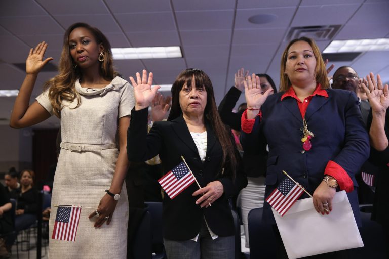 Immaculee Ilibagiza, from Rwanda, (L) and other immigrants take the oath of American citizenship at a naturalization ceremony in New York City.  (Photo by John Moore/Getty Images)