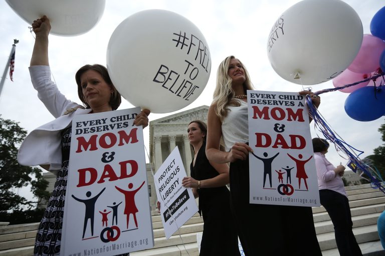 Jennifer Marshall (L) of the Heritage Foundation and Summer Ingram (3rd L) of Congressional Prayer Caucus Foundation hold signs outside the U.S. Supreme Court June 26, 2015 in Washington, D.C. The high court ruled that same-sex couples have the right to marry in all 50 states. (Photo by Alex Wong/Getty Images)