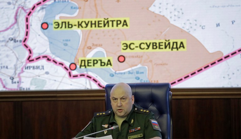 Commander of the Russian forces in Syria speaks with a map of Syria projected on the screen in the back. Russia could begin deploying military police to security zones in Syria after the zones are finalized in two to three weeks, the country's TASS news service reported Tuesday. (AP Photo/Pavel Golovkin)