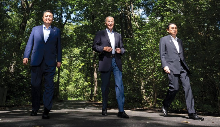 President Joe Biden arrives with South Korean President Yoon Suk Yeol (L) and Japanese Prime Minister Fumio Kishida (R) to a joint press conference at the end of the Trilateral Summit at Camp David in Maryland on August 18.