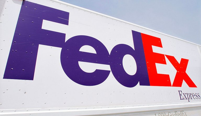 The FedEx logo is seen on a delivery truck Tuesday, June 21, 2011, in Springfield, Ill. FedEx said Thursday, Sept. 15, 2022, that it is shuttering storefronts and corporate offices while putting off new hires in a belt-tightening drive brought on by drop-off in its global package delivery business.