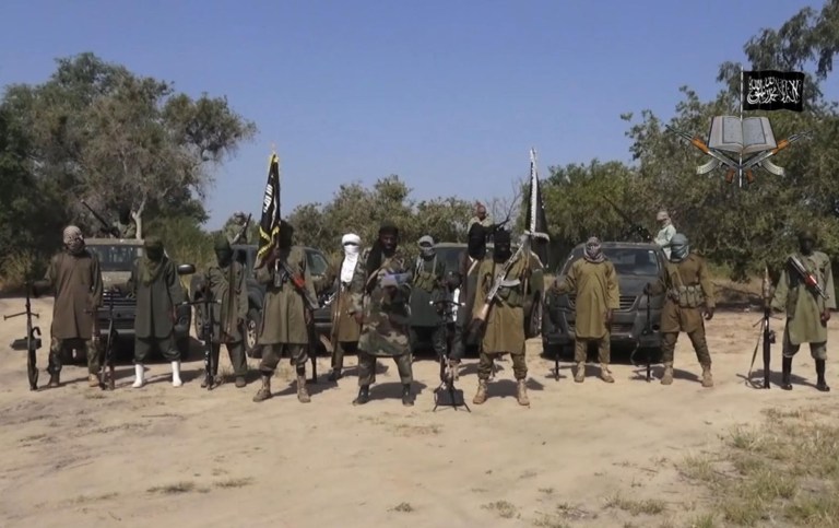 In this file image taken from video released late Friday evening, Oct. 31, 2014, by Boko Haram, Abubakar Shekau, centre, the leader of Nigeria's Islamic extremist group. Boko Haram fighters have shot or burned to death about 90 civilians and wounded 500 in ongoing fighting in a Cameroonian border town near Nigeria, officials in Cameroon said Thursday, Feb. 5, 2015. (AP Photo/Boko Haram, File)