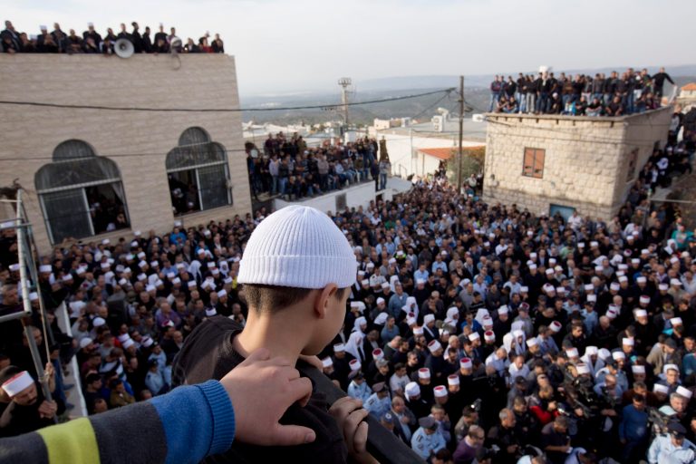 Druze men and relatives attend the funeral of Druze Israeli police officer Zidan Sif in the Druze village of Yanuh-Jat, northern Israel, Wednesday, Nov. 19, 2014. Sif, 30, died of his wounds on Tuesday after two Palestinian cousins armed with meat cleavers and a gun stormed a Jerusalem synagogue during morning prayers Tuesday, killing four people in the city's bloodiest attack in years. Police killed the attackers in a shootout. (AP Photo/Ariel Schalit)
