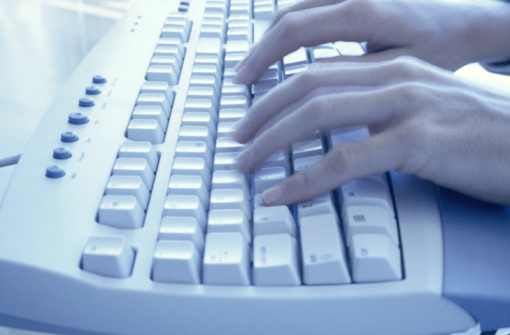 Hands typing on computer