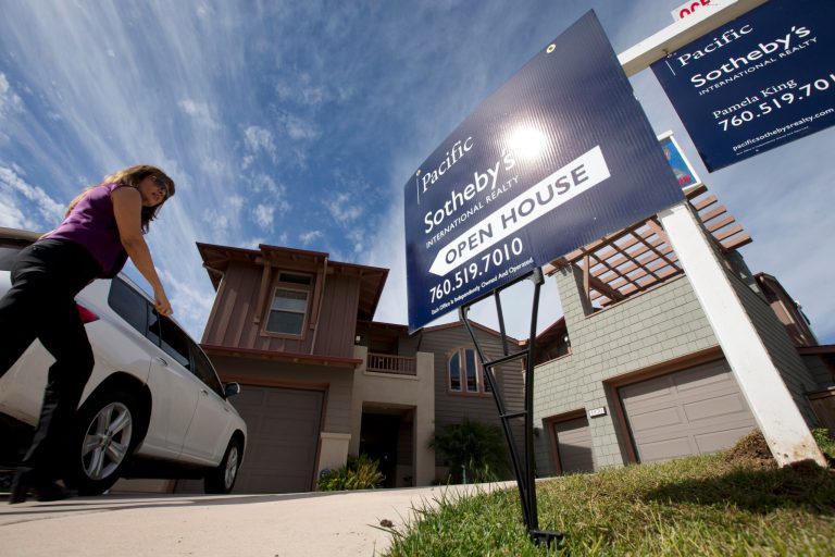   In this Wednesday, Nov. 14, 2012, photo, a woman walks towards a home for sale during a viewing for brokers in Leucadia, Calif. Mortgage buyer Freddie Mac said Thursday, Dec. 13, 2012, that the average rate on the 30-year loan dipped to 3.32 percent. That's below last week's rate of 3.34 percent. And it's just above the 3.31 percent, the lowest rate on records dating to 1971. (AP Photo/Gregory Bull, File)  