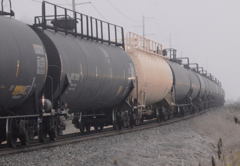 In this Oct. 24, 2013, photo, black tank cars of the type used to transport crude oil from North Dakota head toward a refinery in Anacortes, Wash. Hundreds of rail cars carrying crude oil could soon be chugging across the Northwest, bringing potential jobs and revenues but raising concerns about potential oil spills, increased train traffic and other issues. With five refineries in the state, Washington has long been accustomed to receiving crude oil from Alaska by ship, barges or pipelines. But ports and refineries are now turning to trains to take advantage of a boom in oil from North Dakota's Bakken region. (AP Photo/Skagit Valley Herald, Scott Terrell)