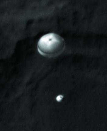 This late Sunday, Aug. 5, 2012 PDT photo made available by NASA shows the Curiosity rover, bottom, and its parachute descending to the surface from the vantage point of the Mars Reconnaissance Orbiter. (AP Photo)