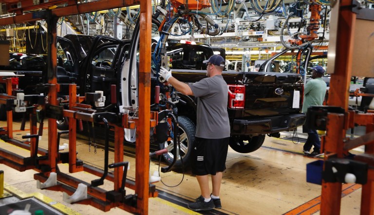 A United Auto Workers assemblyman installs the front doors on a 2018 Ford F-150 truck being assembled at the Ford Rouge assembly plant, Thursday, Sept. 27, 2018, in Dearborn, Mich.