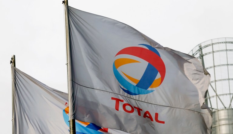 The flag of the French oil giant Total SA is seen in the La Defense  building complex in Puteaux, west of Paris, Tuesday Feb 5, 2013.