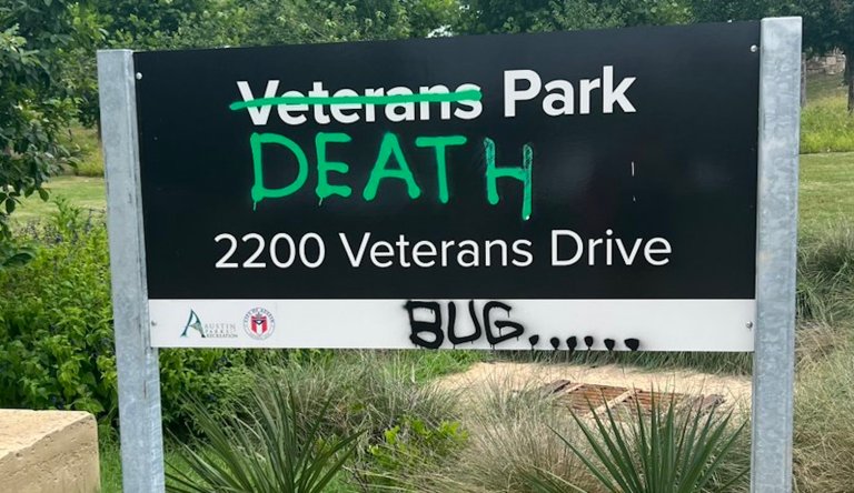 The Veterans Park sign in Austin, Texas, was vandalized with a line through 