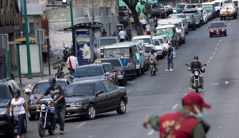 A long line of drivers wait to fill up at a gas station, amid government restrictions on movement to help contain the spread of the new coronavirus in Caracas, Venezuela, Thursday, March 26, 2020. COVID-19 causes mild or moderate symptoms for most people, but for some, especially older adults and people with existing health problems, it can cause more severe illness or death.