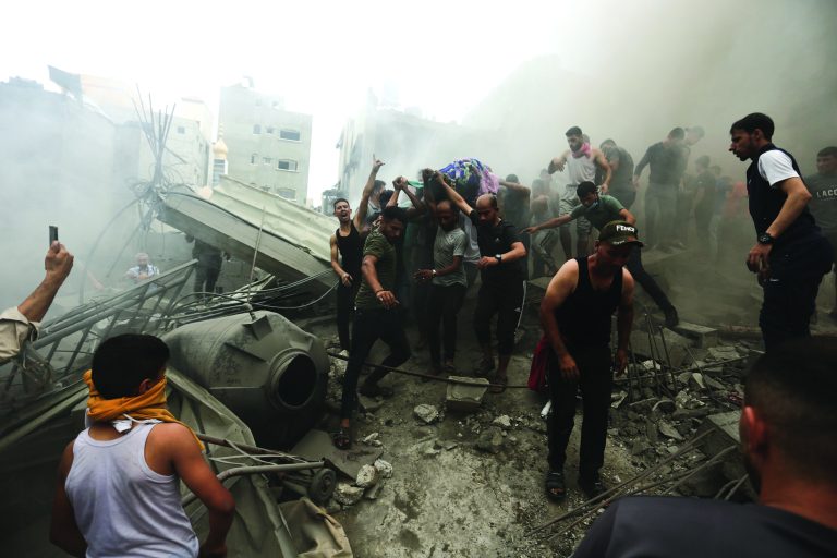 Palestinians remove a dead body from the rubble of a building after an Israeli airstrike Jebaliya refugee camp, Gaza Strip, Monday, Oct. 9, 2023. 