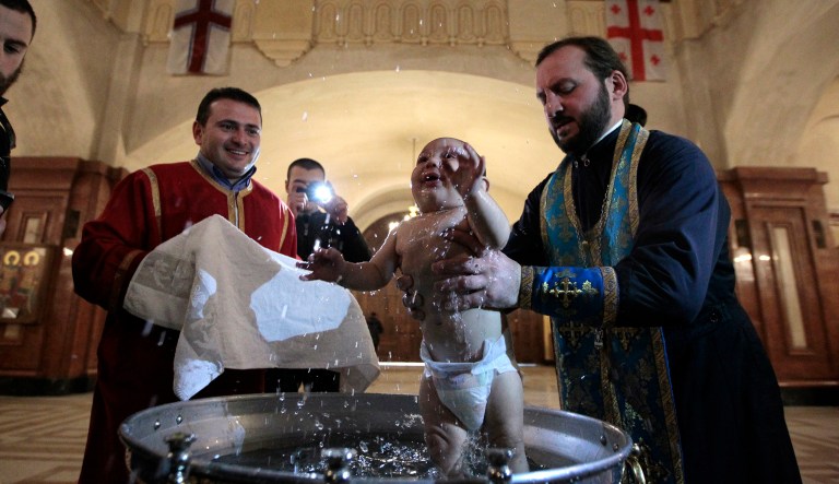A baby is baptized during a mass baptism ceremony in the Holy Trinity Cathedral in Tbilisi, Georgia, Tuesday, Nov. 15, 2016.