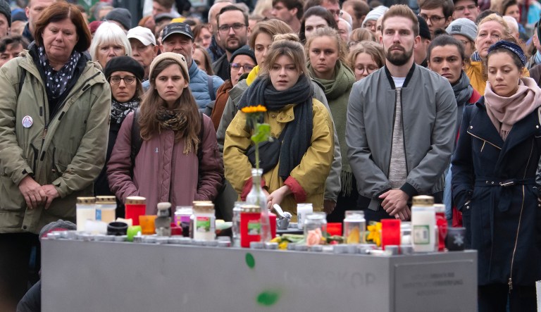 People take part at a minute's silence and a demonstration against anti-semitism at the marketplace in the old town of Halle (Saale), Germany, Friday, Oct. 11, 2019. A heavily armed assailant ranting about Jews tried to force his way into a synagogue in Germany on Yom Kippur, Judaism's holiest day, then shot two people to death nearby in an attack Wednesday that was livestreamed on a popular gaming site.