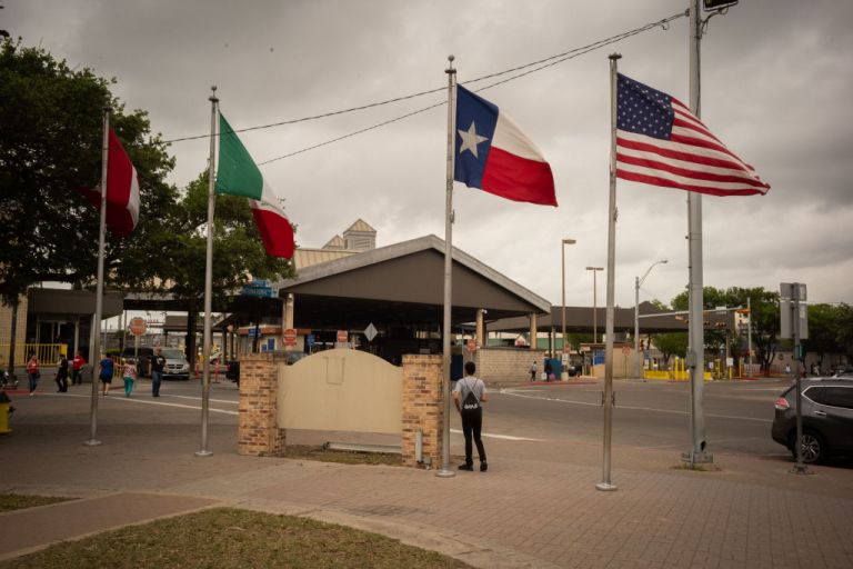 Canadian, Mexican, Texas, and American flags fly at a border crossing in Brownsville, Texas, U.S., on Friday, March 20, 2020. PresidentÂ Donald TrumpÂ said 