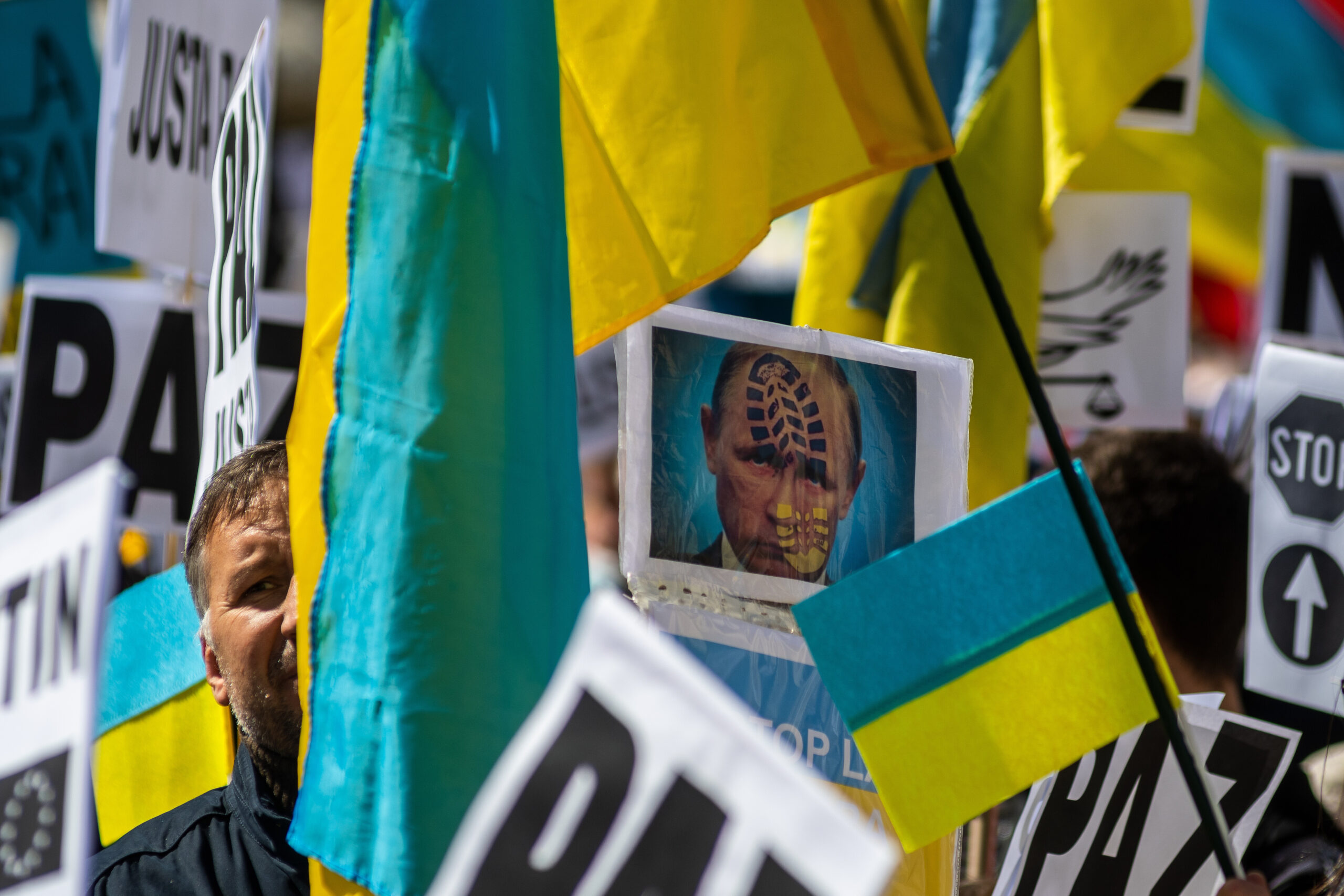 Placards and Ukrainian flags are seen during a demonstration