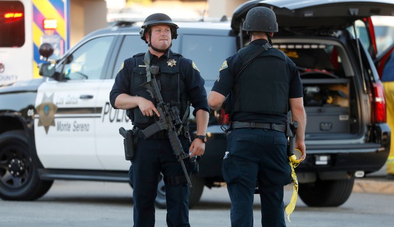 Police stand guard outside Gilroy High School following a deadly shooting at the Gilroy Garlic Festival in Gilroy, Calif., on Sunday, July 28, 2019.