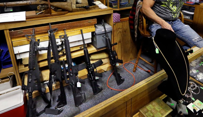 In this Oct. 20, 2017 file photo, Johnny's Auction House owner John West prepares items, including a line of assault rifles at left, for auction where the company handles gun sales for both civilians and a half dozen police departments and the Lewis County Sheriff's Office, in Rochester, Wash.