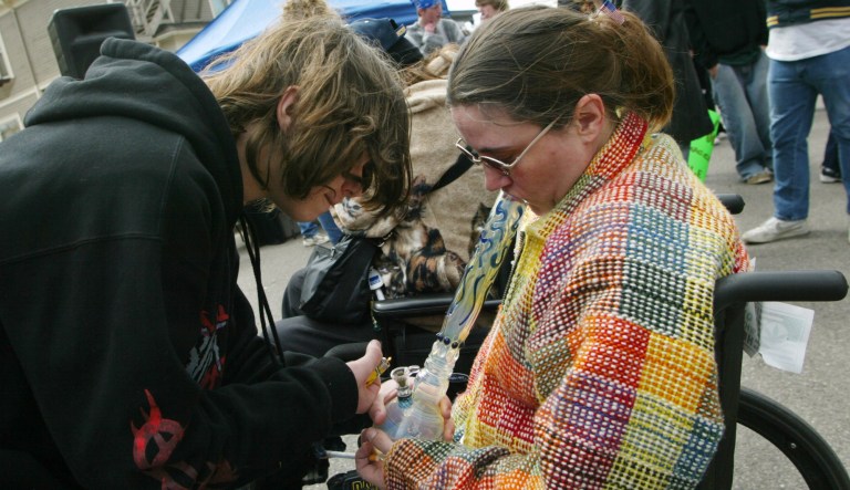 Anthony Franciola, left, helps his mother Jeanean Franciola of Manchester, Mich smoke marijuana as he lights her bong during the 33rd annual Hash Bash celebration where supporters rallied for the legalization of marajuana on April 3, 2004 in Ann Arbor, Mich. Jeanean Franciola has Multiple Sclerosis and smokes marijuana to give her an appetite since going through chemo therapy and being a part of a test group for the Beta Seron drug. Her son helps her smoke because her MS confines her to a wheelchair and she has trouble smoking the bong on her own. 