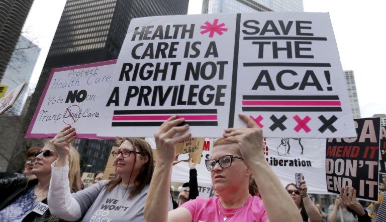 Protesters gather across the Chicago River from Trump Tower to rally against the repeal of the Affordable Care Act, Friday, March 24, 2017, in Chicago.