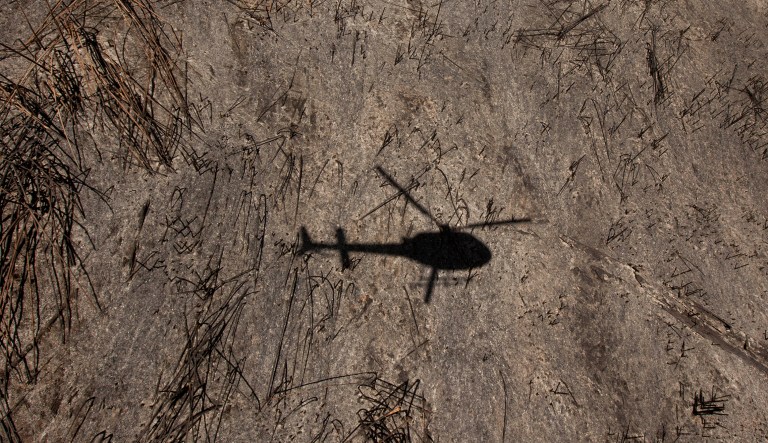 The shadow of a helicopter carrying park officials and media is cast on an area of forest that was burned to the ground by forest fires on the slopes of Mount Kenya, the second-highest peak in Africa at 5,199 meters (17,057 feet), in Kenya Tuesday, March 20, 2012. Fires that have been raging across Mount Kenya may have been set by poachers trying to create a diversion from their illegal attacks on animals, a wildlife official said Tuesday. 