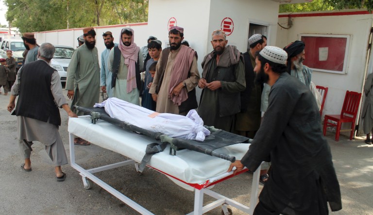 Afghans carry the body of a man who was killed during an attack, in the southern Helmand province, Monday, June 29, 2020. A car bombing and mortar shells fired at a busy market in southern Afghanistan's Helmand province on Monday killed over 20 people, including children, a statement from a provincial governor's office said.
